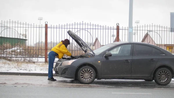Автокатастрофа. Молодая женщина стоит у сломанной машины. В поисках нарушения спокойствия — стоковое фото