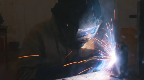 A welder in helmet doing his job. Welding process. Smoke and sparks — Stock Photo, Image