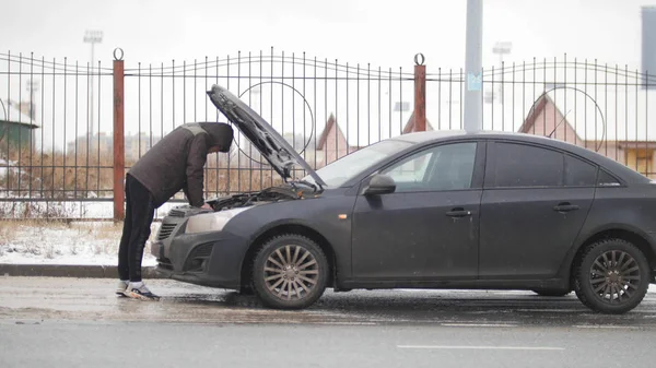 Автокатастрофа. Молодой человек ищет дефекты в сломанной машине . — стоковое фото