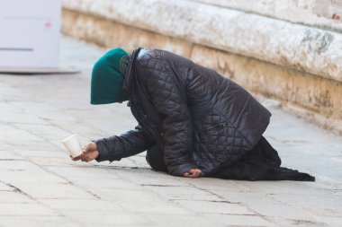Yaşlı bir kadın yardım için İtalya sokaklarında sorar.