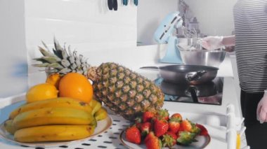 Bir kadın bir kafe içinde ocakta pişiriyor