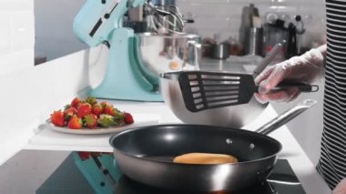 Bir aşçı bir tavada krep yapıyor