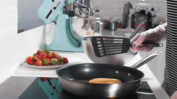 Een kok is het maken van pannenkoeken in een pan — Stockvideo