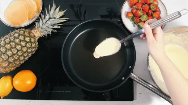 Девушка делает блинчики на сковороде — стоковое видео