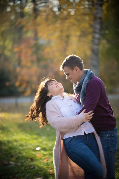 A man tilts a woman to dance in the autumn park — Stock Photo, Image