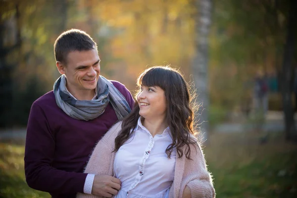 Um casal apaixonado olha um para o outro olhos no parque de outono — Fotografia de Stock