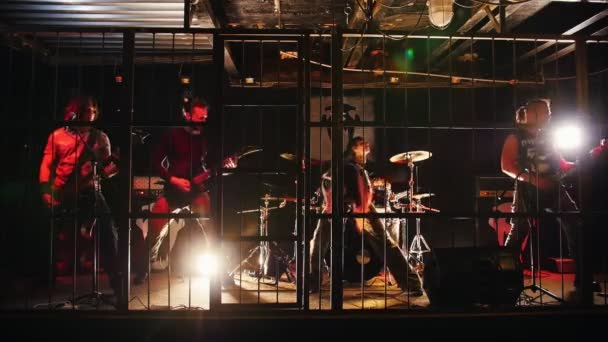Rock band performs on stage in a cage — Stock Video