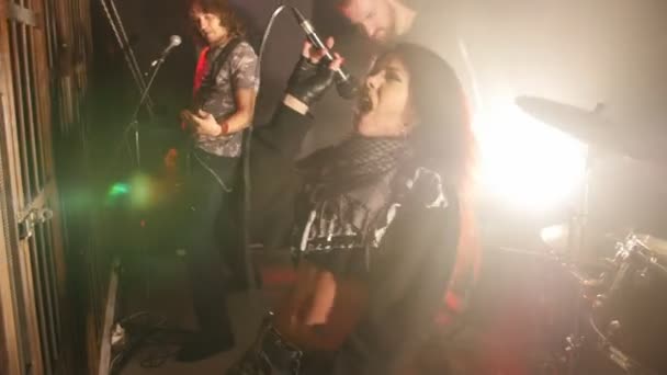A cantora toca emocionalmente uma música em uma banda de rock de concerto — Vídeo de Stock