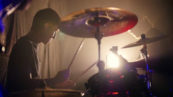 Jongeman emotioneel het bespelen van drums in een rock band en gitaar te spelen op de achtergrond — Stockvideo