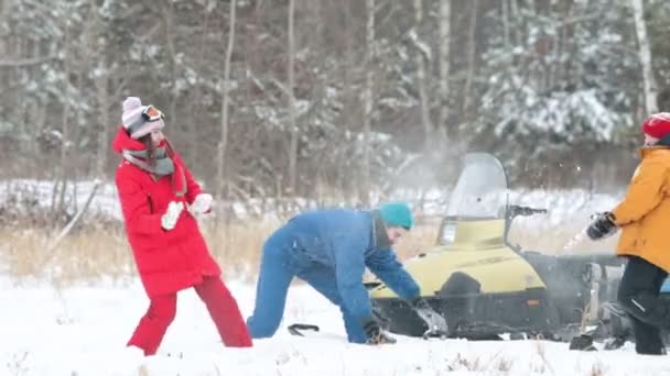 La familia juega en la nieve cerca de una moto de nieve en el bosque de invierno — Vídeos de Stock