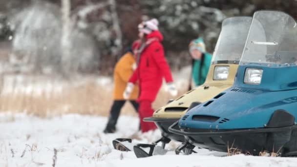 Κοντά σε snowmobile η οικογένεια παίζει στο χιόνι στο δάσος — Αρχείο Βίντεο