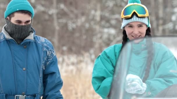 Zimą. Młody mężczyzna i kobieta w zimowym lesie. Kobieta formowania kuli śniegowej. Zwolnionym tempie — Wideo stockowe