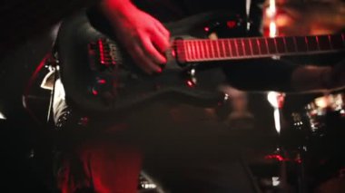 Siyah bir gitar bir sahnede oynarken gitarist.