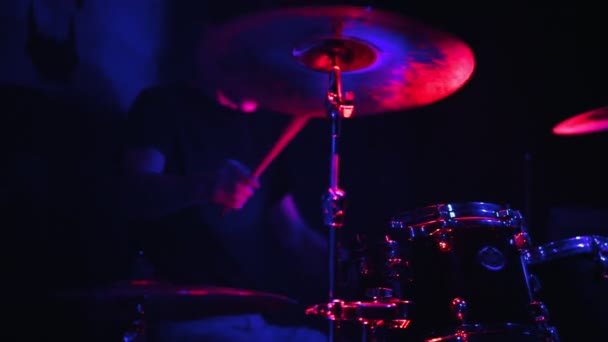 Een man het bespelen van drums op een sombere podium. Neon verlichting — Stockvideo