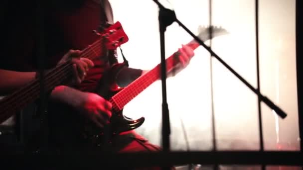 Κιθαρίστας παίζει με ενθουσιασμό σε μια σκηνή σε μια μαύρη κιθάρα. Καπνιστή στάδιο — Αρχείο Βίντεο