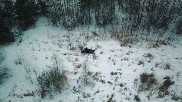 En vinter skog. Två människor ridning skotern — Stockvideo