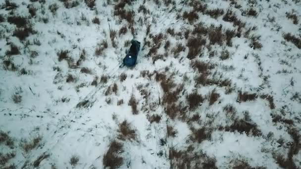 Un bosque de invierno. Dos personas montando en la moto de nieve. Disparos en helicóptero — Vídeo de stock