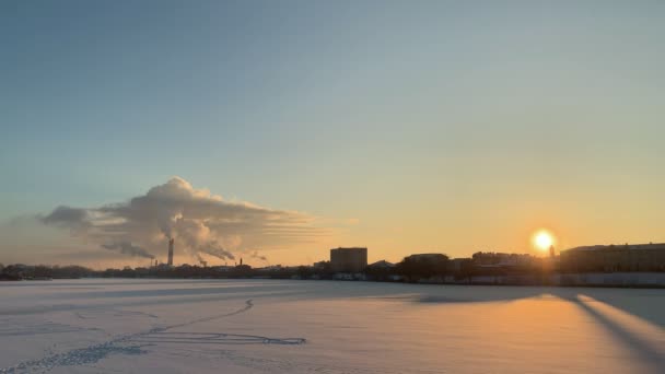 Зимовий індустріальний пейзаж над засніженим містом на заході сонця — стокове відео