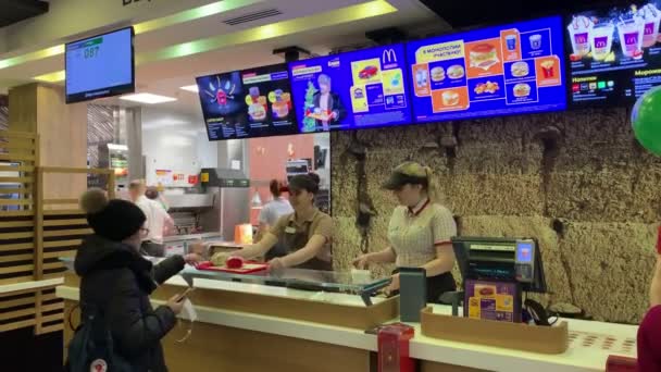RUSIA, KAZAN 18-12-2018: un trabajador de McDonalds recoge una orden y se la da al cliente dentro de un gran centro comercial — Vídeos de Stock