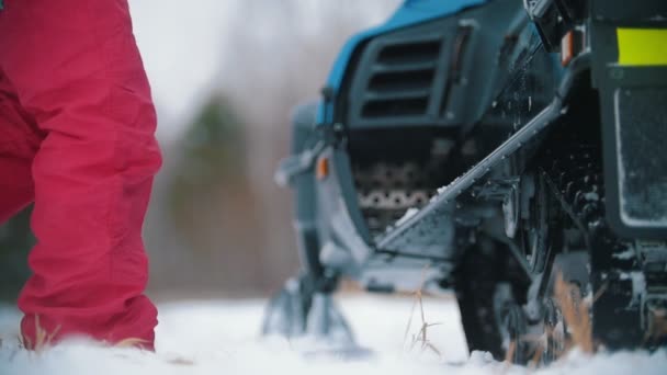 Jovens em roupas brilhantes entrando na moto de neve — Vídeo de Stock