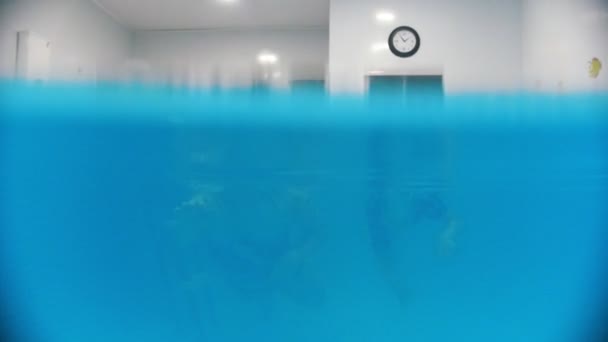 Water rehabilitation procedure with child with cerebral palsy. A baby swimming with instructor — Stock Video