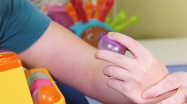 Serebral Palsili çocuk ile bir meslek. İnce motor becerileri developmenting. Küçük tutan çocuk topları ve doğru yerlere ekler