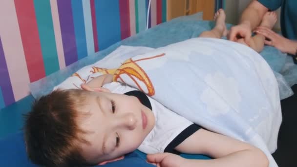 Clinique médicale. Une occupation avec un enfant atteint de paralysie cérébrale. Massage relaxant des jambes — Video