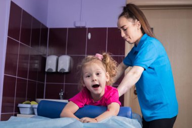 Fizyoterapi ile Serebral Palsili çocuk. Klinik, küçük bir kız kanepede yatıyor