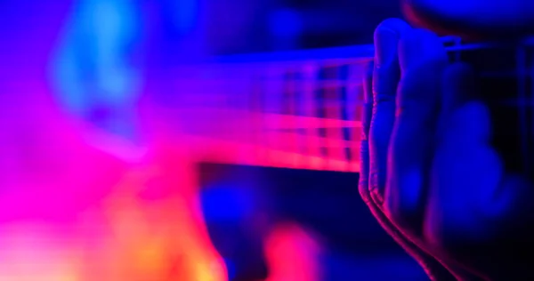 Рок-концерт. Гітарист грає на гітарі з освітленими лампами. Рука крупним планом — стокове фото