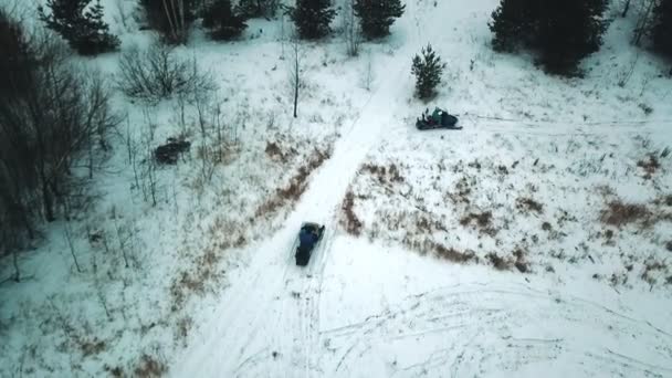 年轻人在冬天的森林里骑雪地摩托。直升机射击. — 图库视频影像