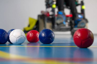 Boccia. Tekerlekli sandalyede oturan bir Engelli adam. Boccia oynamak için küçük topları kapatın. Üç renkli.