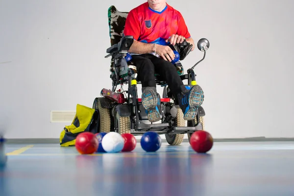 Boccia. ein behinderter Sportler, der im Rollstuhl vor Bällen sitzt. kleine Bälle zum Boccia spielen. — Stockfoto
