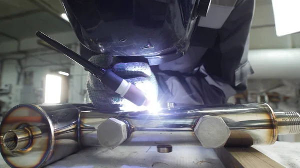 Industrial manufacturing. A man working with an iron pipe detail. Welding