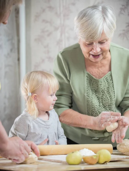 Старушка наслаждается, делая маленькие яблочные пирожки с внучкой . — стоковое фото