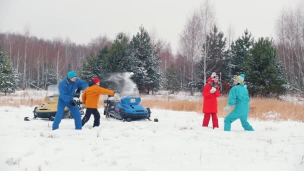 Bosque de invierno. Una familia joven divirtiéndose jugando bolas de nieve. Chicas contra chicos. Movimiento lento — Vídeo de stock