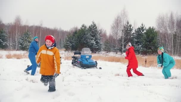 Bosque de invierno. Una familia joven divirtiéndose jugando bolas de nieve. Movimiento lento — Vídeo de stock