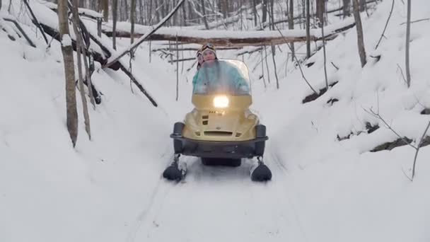 Winter forest. Jongeren over sneeuwscooters naar beneden weg op een speciale track — Stockvideo