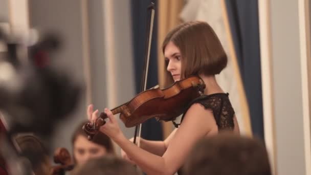 Камерний оркестр. Молода жінка грає на скрипці — стокове відео