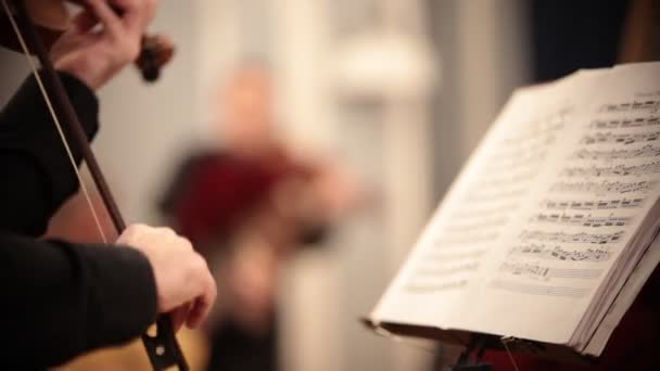 Kammerorchester. Ein Mann steht und spielt Geige nach Noten — Stockvideo