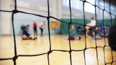 Engelliler için spor. Katta oturan ve voleybol oynayan insanlar. Odak kılavuzunda