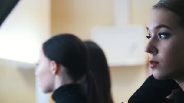 Entre bastidores. Modelos en el estudio. Mujer joven arreglando su cabello — Vídeos de Stock