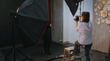 Genç kadın modelinde bir fotoğraf oturumu stüdyoda. Sahne arkasında çekim