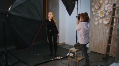 Sarışın genç kadın modelinde bir fotoğraf oturumu stüdyoda. Sahne arkasında çekim