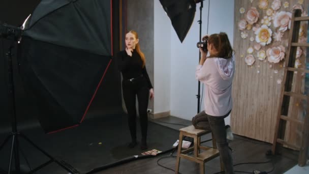 Joven modelo rubia teniendo una sesión de fotos en el estudio. Disparos entre bastidores — Vídeo de stock