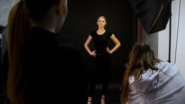 Genç kadın modelinde bir fotoğraf oturumu stüdyoda. Model siyah giysilerle çekim. Tam yüksekliği çekim