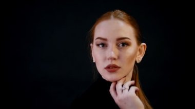 Photosession. Genç güzel kadın modeli portresi. Kızıl saçlı, bronz makyaj. Etrafında döner ve kamerada görünüyor