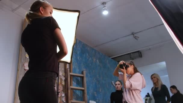 Росія, Казані. 14-12-2018: молода жінка моделі мають Фотосесія в студії і інші моделі, які чекають своєї черги. За лаштунками зйомки — стокове відео