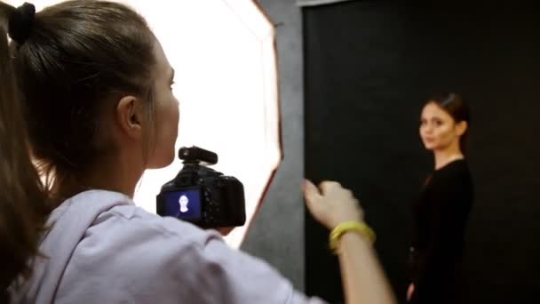 RUSIA, KAZAN. 14-12-2018: Mujer joven modelo teniendo una sesión de fotos en el estudio. Disparando entre bastidores. El fotógrafo le dice al modelo cómo posar — Vídeos de Stock