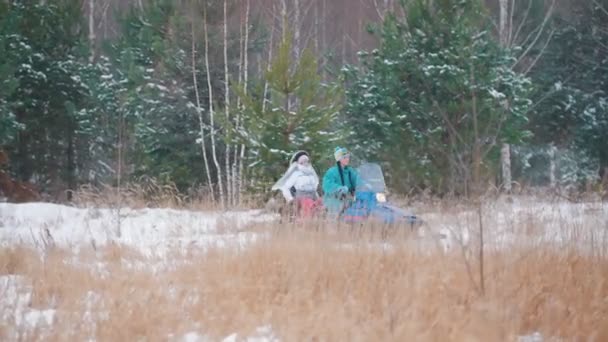 Winterwald. Junge Leute fahren Motorschlitten mit hoher Geschwindigkeit — Stockvideo