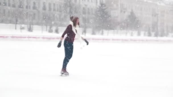 A young smiling woman ice skating outside. — Stock Video